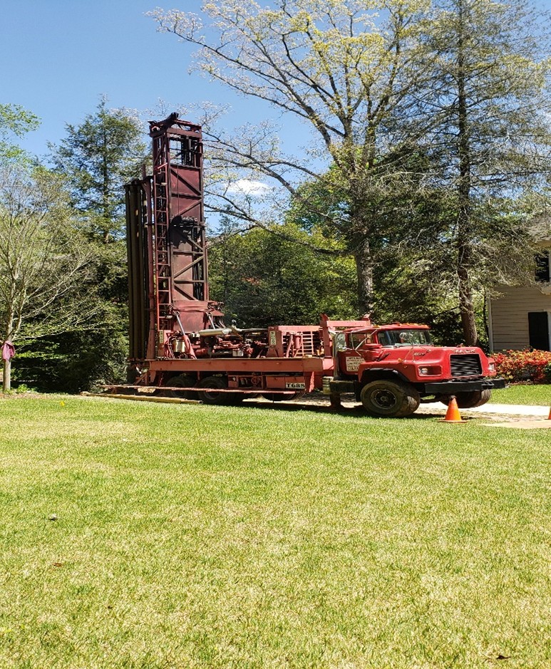 Hydraulic boring machine into a construction site for drilling piles.